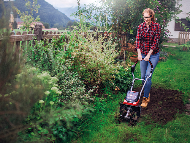 Bodenpflege Frau m Garten auf Beet