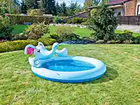 Ein aufblasbares Elefanten-Kinderplanschbecken steht auf einem grünen Rasen im Garten.