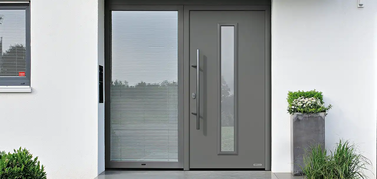 Graue Haustür mit bodenlangem Fenster und weißer Hauswand Graue Haustür mit bodenlangem Fenster und weißer Hauswand