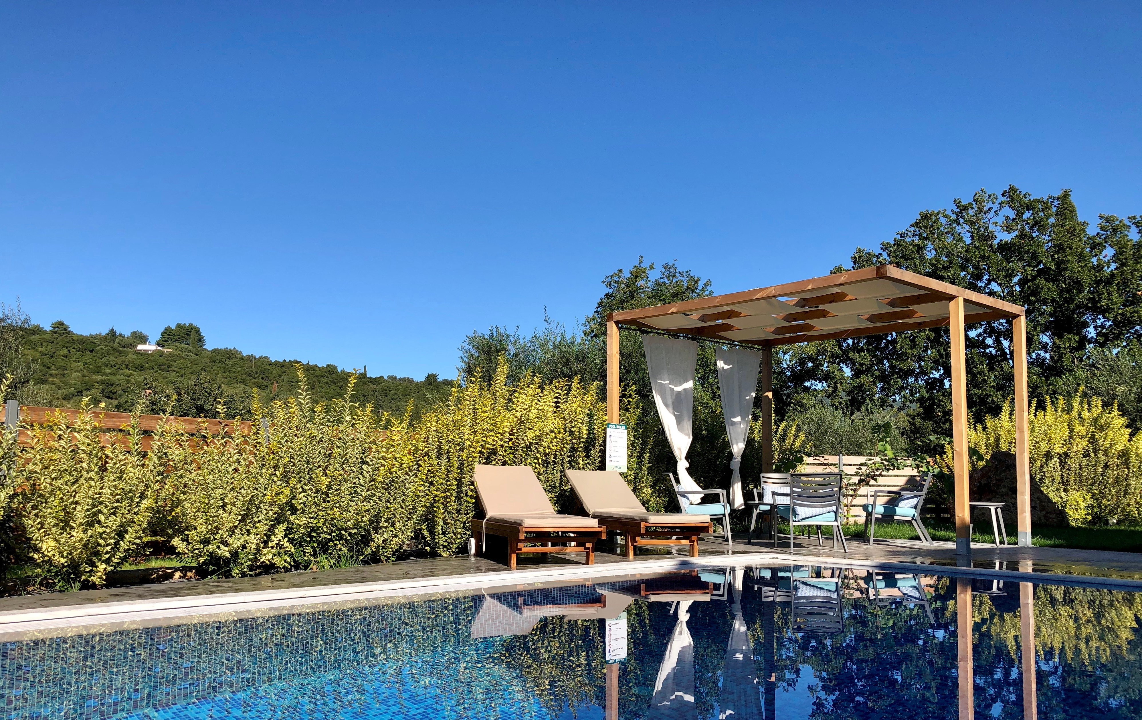 Sonnenschutz aus Holz am Pool mit Gartenliegen 