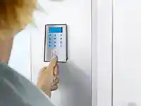 Eine Person öffnet mittels Fingerabdruck auf einer Klingel die Haustür.